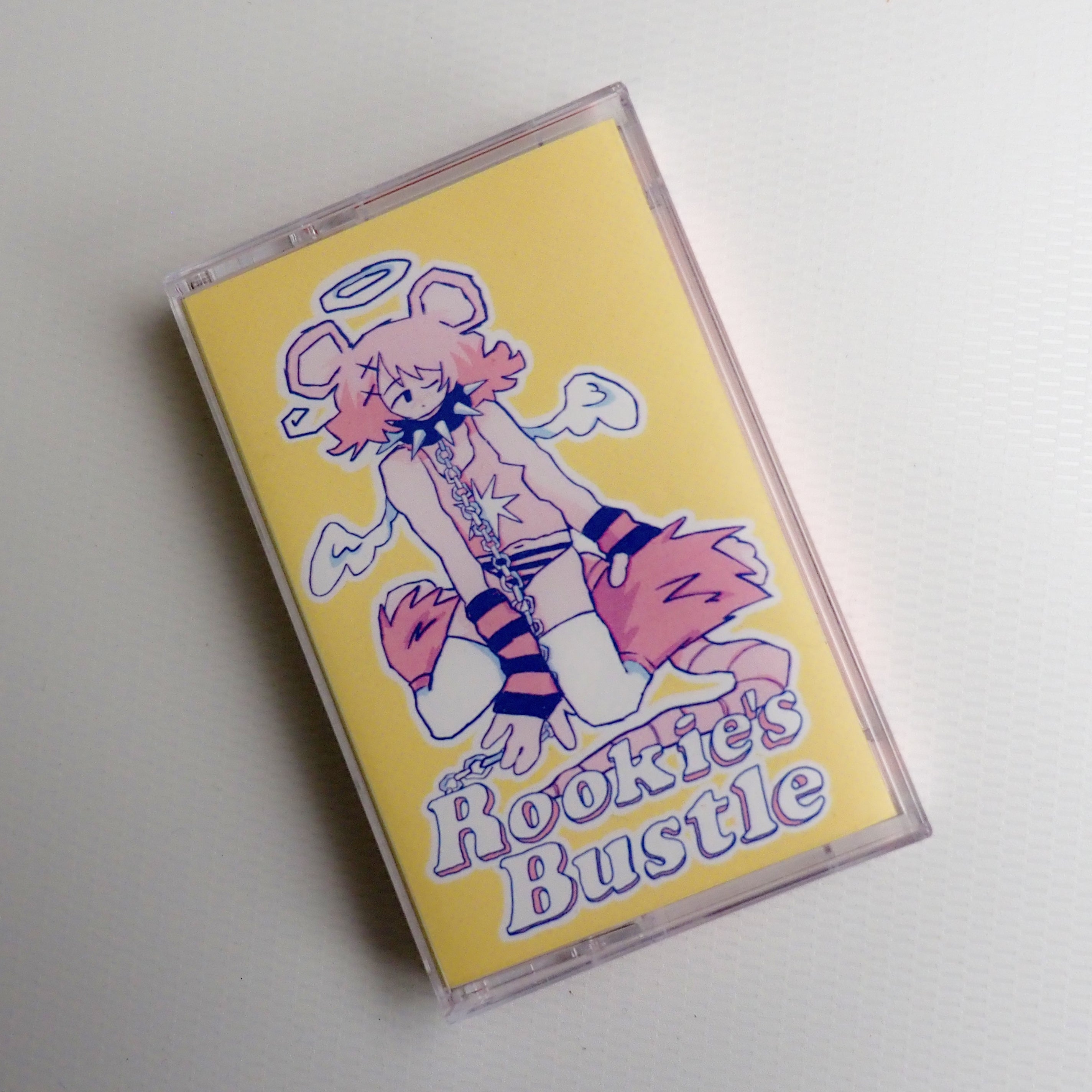 "Rookie's Bustle" Cassette tape case art with an illustration of a character on a yellow background