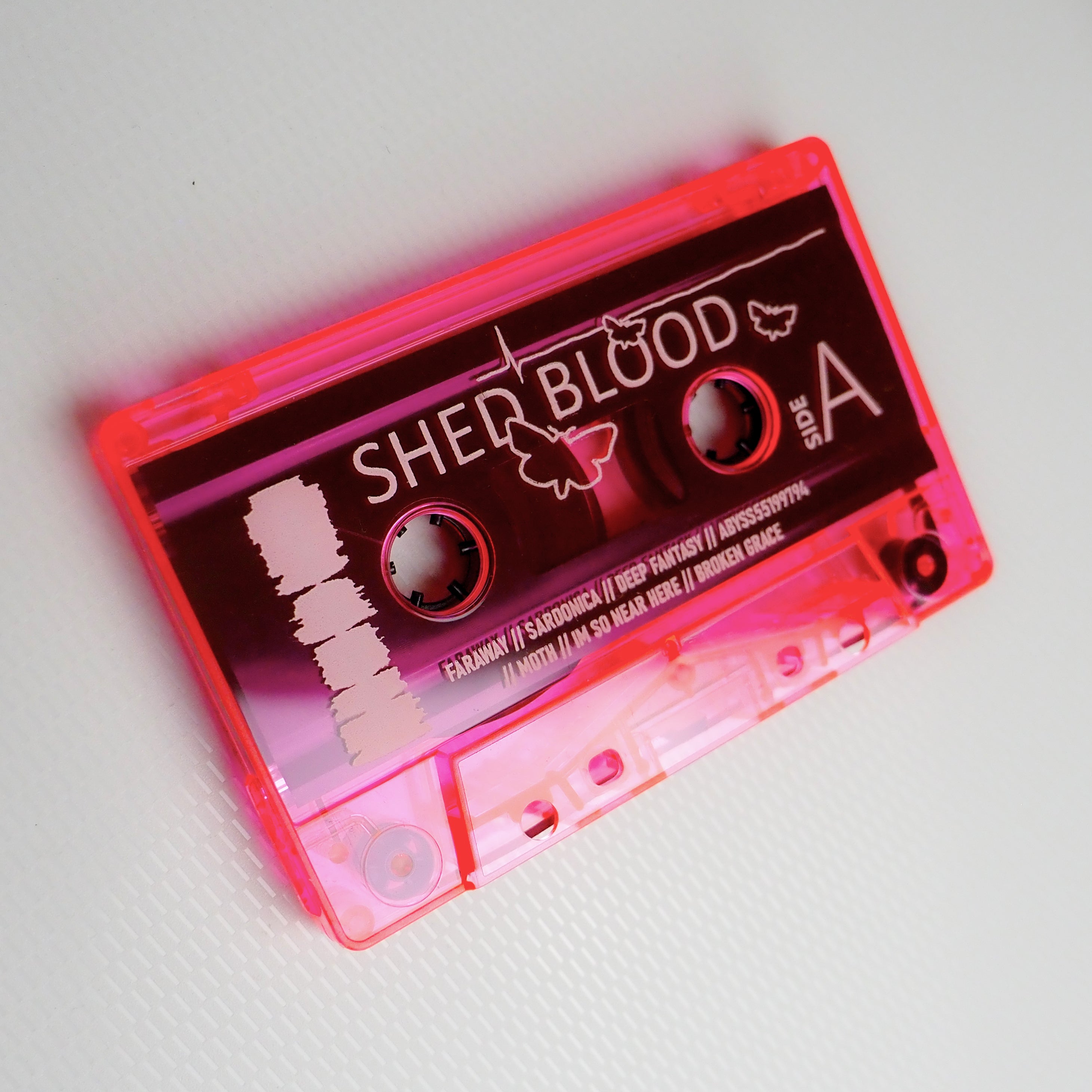 Pink transparent cassette tape for 'SHED BLOOD' on a white background