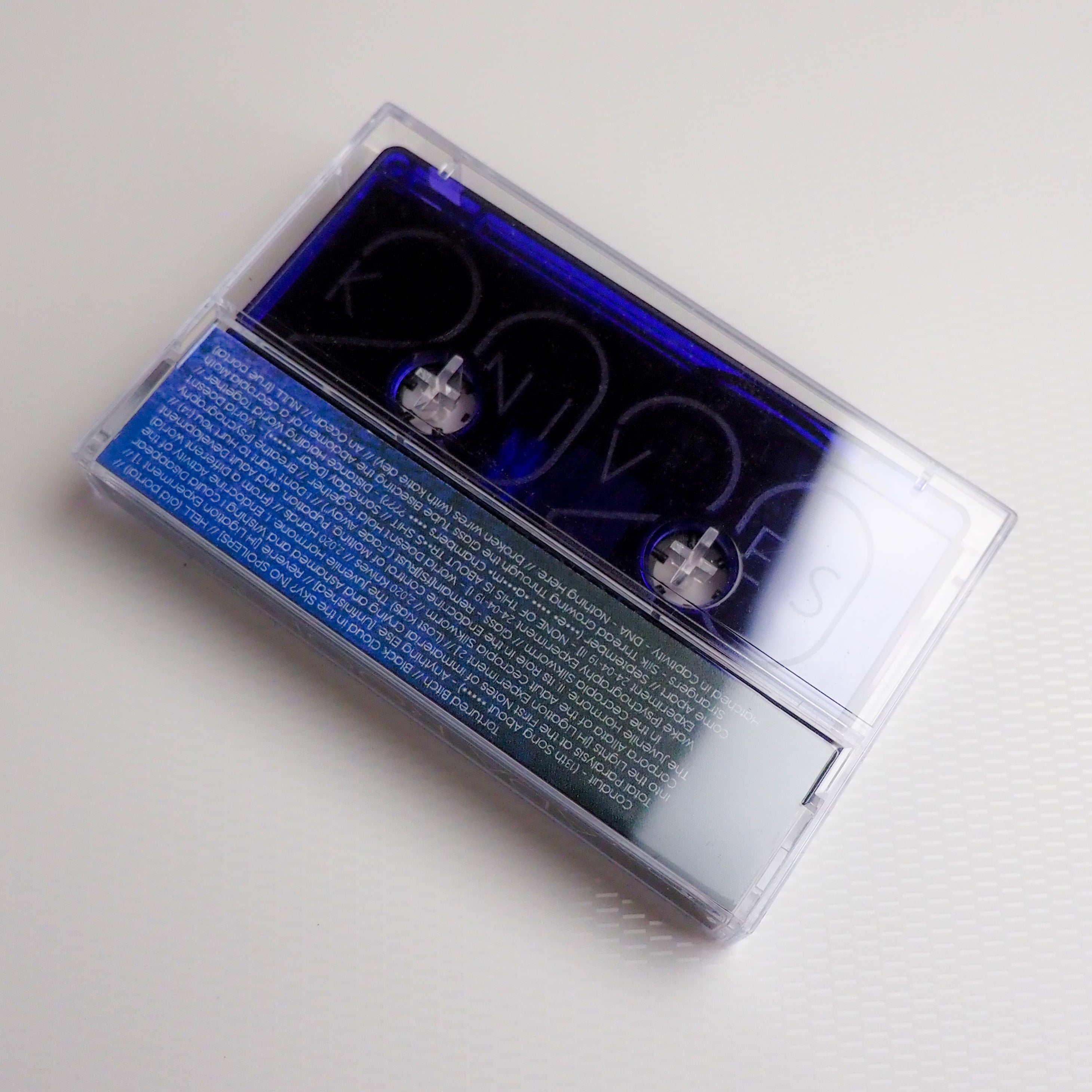 Closed Clear cassette tape back for "2020 Knives" with blue label on a white background